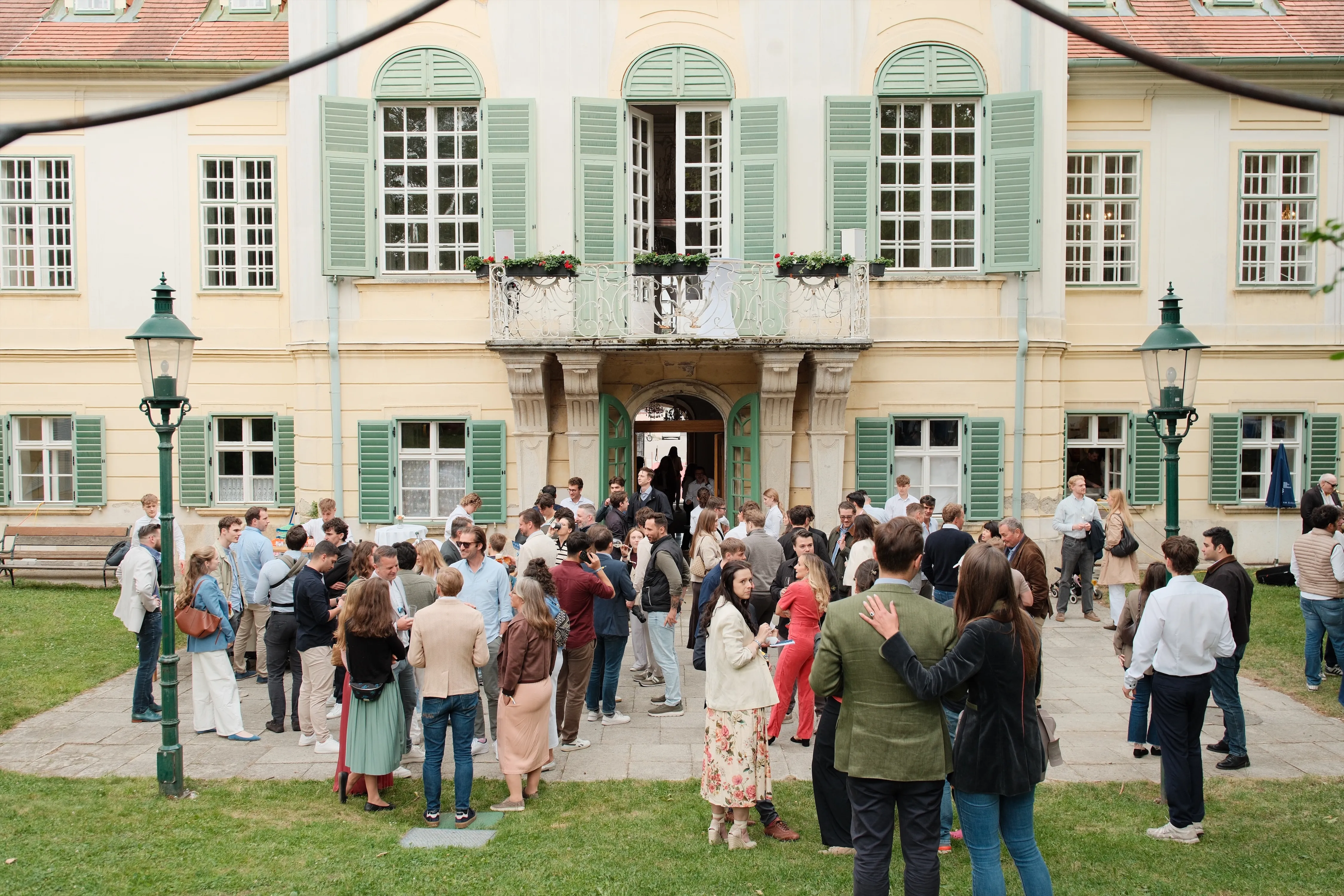 Summer party in front of Schloss Hunyadi with many guests in the courtyard